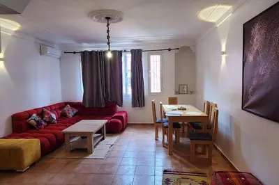 a living room with a red couch and a table at Appartement bien équipé à louer in Marrakech