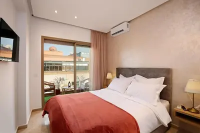 a bedroom with a large bed and a balcony at Elegant and Brand new appart in hypercenter of Marrakech in Marrakech