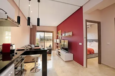a room with a red wall and a bedroom at Elegant and Brand new appart in hypercenter of Marrakech in Marrakech