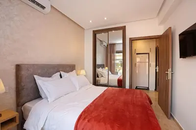 a bedroom with a large white bed with a red blanket at Elegant and Brand new appart in hypercenter of Marrakech in Marrakech