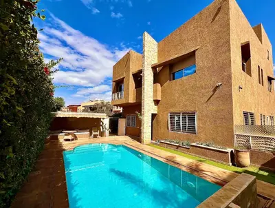a swimming pool in the yard of a house at Villa des Ocres - Élégance et Luxe à 15 min du centre ! in Marrakech