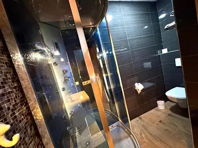 a bathroom with a shower with a glass door at Villa des Ocres - Élégance et Luxe à 15 min du centre ! in Marrakech