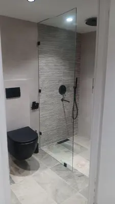 a bathroom with a shower with a black toilet at Duplex au cœur de marrakech in Marrakech