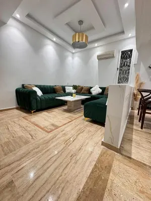 a living room with a green couch and a table at Duplex au cœur de marrakech in Marrakech