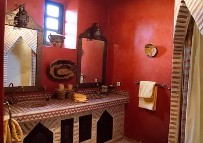 a bathroom with a sink and a large mirror at Riad Amirat Al Jamal in Marrakech