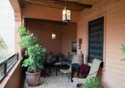 a porch with chairs and tables on a balcony at Riad Amirat Al Jamal in Marrakech