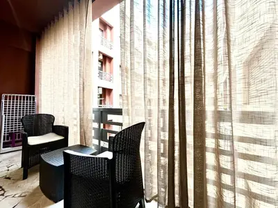 a balcony with chairs and a table and a window at Le Spacieux de Gueliz avec Piscine et Terasse in Marrakech