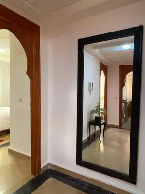 a mirror on a wall in a room with a table at Refined apartment DOWNTOWN in Marrakech