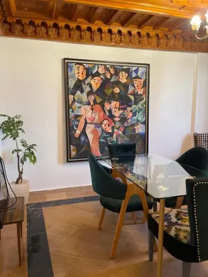 a dining room with a painting on the wall at Refined apartment DOWNTOWN in Marrakech