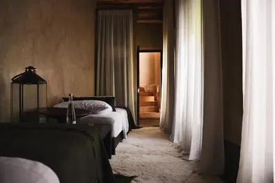 a bedroom with a bed and a table and curtains at Riad Muarid in Marrakech