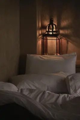 a bedroom with a white bed with a lamp on it at Riad Muarid in Marrakech