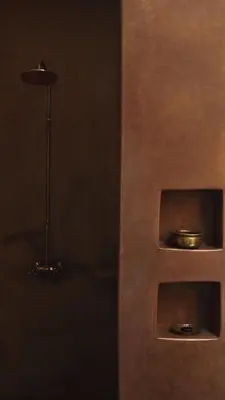 a wooden shelf with a bowl on it next to a lamp at Riad Muarid in Marrakech