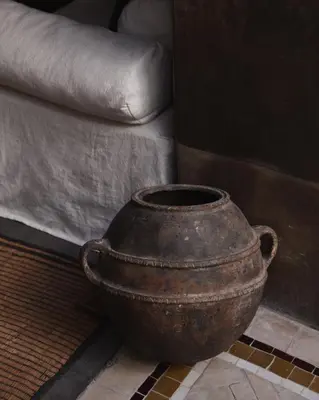 an old pot sitting next to a couch at Riad Muarid in Marrakech