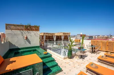a rooftop patio with a swimming pool on a building at Yacouta Riad and Spa in Marrakech
