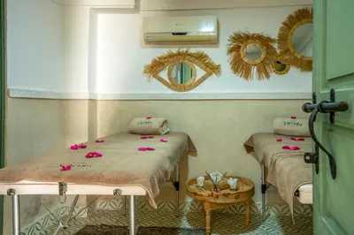 two beds in a room with pink flowers on them at Yacouta Riad and Spa in Marrakech