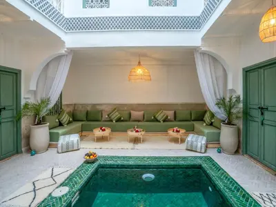 a living room with a green couch and a pool at Yacouta Riad and Spa in Marrakech