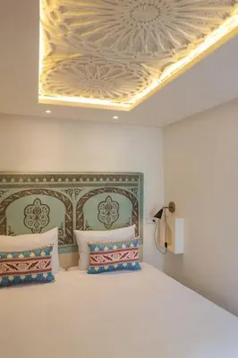 a bedroom with a bed with a coffered ceiling at Riad Pistache 135m2 in der Medina mit Terrasse in Marrakech