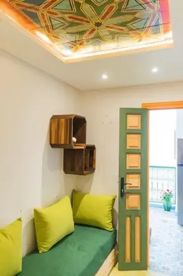 a living room with a green couch and a ceiling at Riad Pistache 135m2 in der Medina mit Terrasse in Marrakech