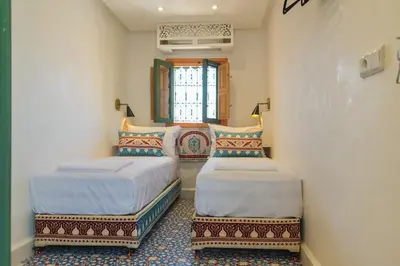 a bedroom with two beds and a window at Riad Pistache 135m2 in der Medina mit Terrasse in Marrakech