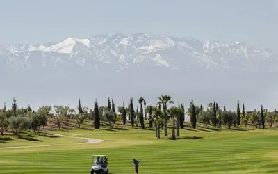 a man standing on a golf course with mountains in the background at VILLA Atlas in Sraghna