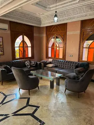a living room with couches and a table and chairs at Villa riad al salam in Marrakech