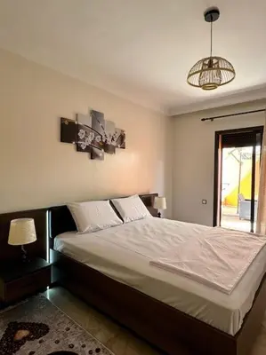 a bedroom with a large bed with a window at Cosy Appartement Famille in Marrakech