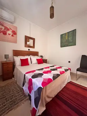 a bedroom with a large bed and a chair at Majorelle Chillax in Marrakech
