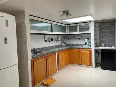 a kitchen with wooden cabinets and a white refrigerator at Majorelle Chillax in Marrakech