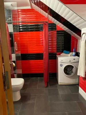 a red bathroom with a toilet and a washing machine at Majorelle Chillax in Marrakech