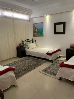 a bedroom with two beds and a rug at Majorelle Chillax in Marrakech