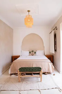 a bedroom with a large bed with a green bench at Riad Eden Dorient in Marrakech
