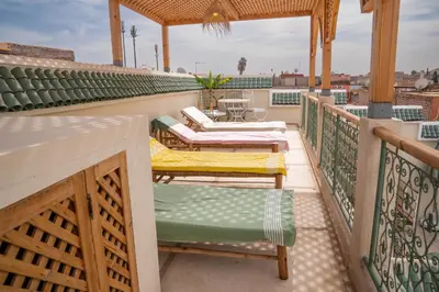 a balcony with chairs and a table on a roof at Riad Eden Dorient in Marrakech