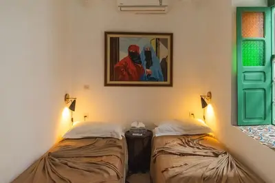 a room with two beds and a painting on the wall at Riad Moulaty 205m2 in der Medina mit Terrasse in Marrakech