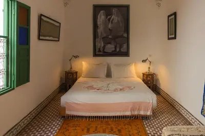 a bedroom with a white bed with two night stands at Riad Moulaty 205m2 in der Medina mit Terrasse in Marrakech