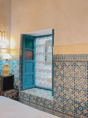a room with a blue door and a tiled wall at Riad Bouhalla 240m2 in der Medina mit Terrasse in Marrakech