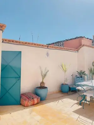 a patio with potted plants and a blue door at Riad Bouhalla 240m2 in der Medina mit Terrasse in Marrakech