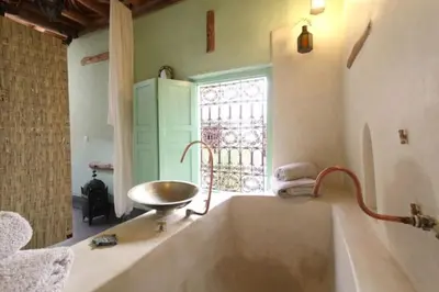 a bathroom with a tub and a sink and a window at Riad Petit Palais 100m2 in der Medina mit Terrasse in Marrakech