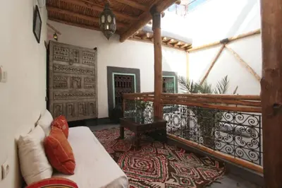 a living room with a couch on a balcony at Riad Petit Palais 100m2 in der Medina mit Terrasse in Marrakech
