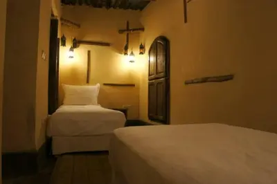 a hotel room with two beds and a door at Riad Petit Palais 100m2 in der Medina mit Terrasse in Marrakech