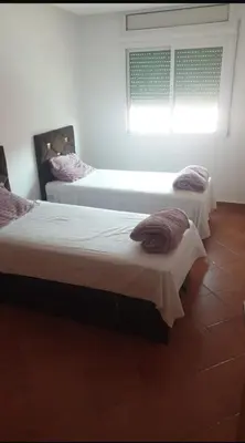 two beds in a room with a window at La Paix Appart in Marrakech