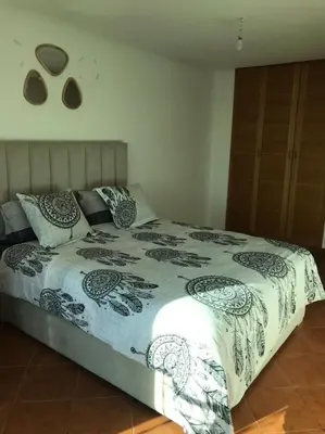 a bed with a black and white blanket and pillows at La Paix Appart in Marrakech