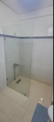 a bathroom with a glass shower with a toilet at La Paix Appart in Marrakech