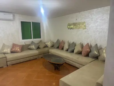 a living room with a couch with many pillows at La Paix Appart in Marrakech