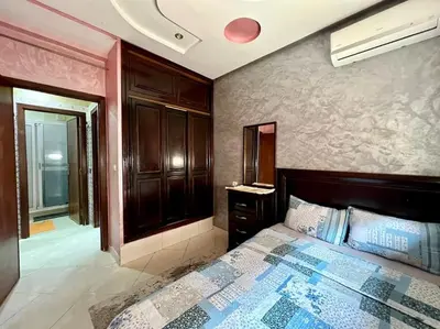 a bedroom with a bed and a room with a window at appart Confortable BASSATIN GUILIZ in Marrakech
