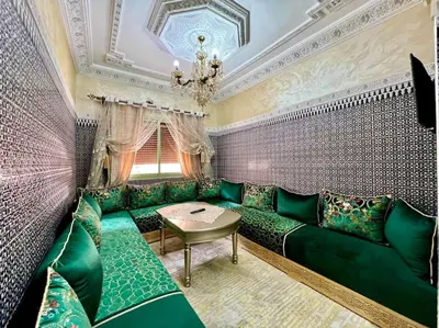 a living room with green couch and a table at appart Confortable BASSATIN GUILIZ in Marrakech
