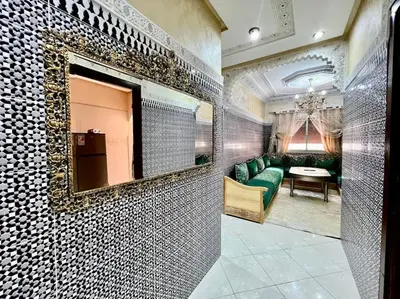 a living room with a green couch and a mirror at appart Confortable BASSATIN GUILIZ in Marrakech