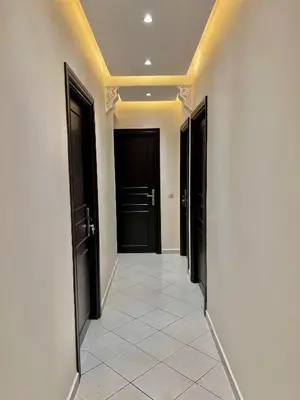 a hallway with black doors and a tile floor at Excellent apparentement, in Marrakech
