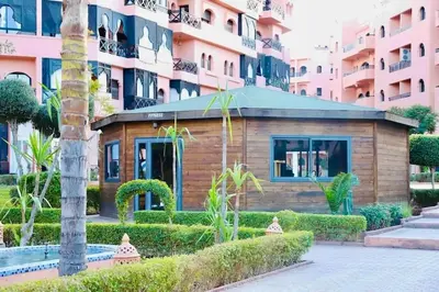 a small building in front of a building at Resort med 24t sikkerhet og basseng - nærme Gueliz in Marrakech