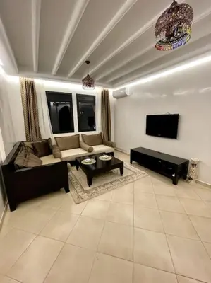a living room with a couch and a tv at Resort med 24t sikkerhet og basseng - nærme Gueliz in Marrakech