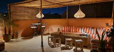 a patio with a couch and a table and chairs at Riad Babmoon - Private Riad with Pool & Rooftop in Marrakech